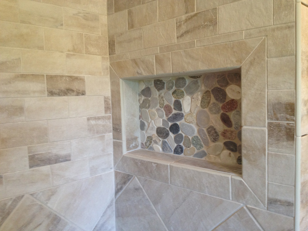 We customize the shower with the soap stone bench, threshold and half wall. The pebble stone floor really looks great