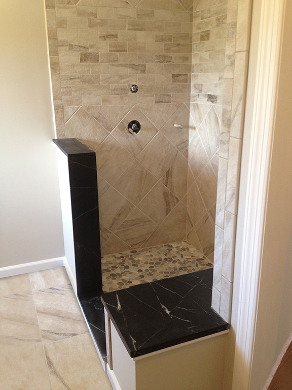 We customize the shower with the soap stone bench, threshold and half wall. The pebble stone floor really looks great